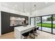 Modern kitchen with a waterfall island, sleek cabinets, pendant lighting, and access to the outdoor space at 3817 W San Nicholas St, Tampa, FL 33629