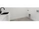 Laundry room features sleek cabinets, a modern black faucet, and neutral flooring at 3817 W San Nicholas St, Tampa, FL 33629