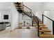 Living room with floating staircase, light wood floors, large windows, and neutral-toned furniture exudes modern elegance at 3817 W San Nicholas St, Tampa, FL 33629