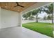 Covered patio featuring tile floors, tongue-and-groove ceiling, and a view of the manicured lawn and surrounding trees at 3817 W San Nicholas St, Tampa, FL 33629