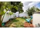 Lush backyard with a white fence, tropical plants, and a comfortable seating area with a blue chair at 4601 83Rd N Ave, Pinellas Park, FL 33781