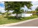 Landscaped front yard featuring palm trees, a large shade tree, and a white fence at 4601 83Rd N Ave, Pinellas Park, FL 33781