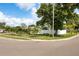 Landscaped front yard featuring palm trees, a large shade tree, and a white fence at 4601 83Rd N Ave, Pinellas Park, FL 33781