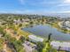 Aerial view showcases a beautiful community with a central lake, a tennis court, and views of the ocean at 4734 Cobia Se Dr # A, St Petersburg, FL 33705