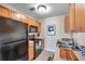 A functional kitchen featuring sleek black appliances, wood cabinets, and ample countertop space at 4734 Cobia Se Dr # A, St Petersburg, FL 33705