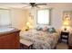 Bright bedroom with a floral comforter and a pair of side tables illuminated by lamps, plus two bright windows at 4922 Genesis Ave, Holiday, FL 34690
