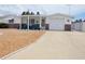 Single-story home boasts a covered porch, attached garage, and long driveway leading to a well-manicured yard at 4922 Genesis Ave, Holiday, FL 34690