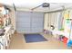 Well-organized garage with tool racks, shelves, and a large gray garage door, plus an arrangement of cleaning supplies at 4922 Genesis Ave, Holiday, FL 34690