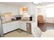 Bright kitchen featuring white cabinetry, sleek appliances, and a view into an adjacent cozy sitting area at 4922 Genesis Ave, Holiday, FL 34690