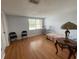 Bright bedroom featuring wood laminate flooring, window, and seating area at 4967 Steel Dust Ln, Lutz, FL 33559