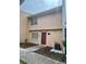 Two-story tan home with manicured lawn, garden, and walkway to the maroon front door at 4967 Steel Dust Ln, Lutz, FL 33559
