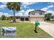 Charming two-story home with a lush green lawn, palm tree, a view of a waterway, and a two-car garage at 5144 Cedarbrook Ln, Hernando Beach, FL 34607