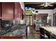 Kitchen featuring granite counters, a stove, an island with seating, and dark wood cabinets at 5144 Cedarbrook Ln, Hernando Beach, FL 34607