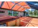 Relaxing patio with an orange awning, a jacuzzi, and a view of the landscaped backyard at 5144 Cedarbrook Ln, Hernando Beach, FL 34607