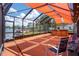 Enclosed patio featuring a hot tub, seating, and view of the water and neighborhood at 5144 Cedarbrook Ln, Hernando Beach, FL 34607