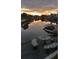 Scenic waterfront view with dock, boats, and a mosaic table set against a vibrant sunset at 5144 Cedarbrook Ln, Hernando Beach, FL 34607
