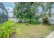 Backyard featuring a grassy area, landscaping and a fire pit, partially enclosed by a white fence at 5317 Pagnotta Pl, Lutz, FL 33558