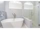 Freestanding tub with modern fixtures, next to a glass-enclosed shower at 5317 Pagnotta Pl, Lutz, FL 33558