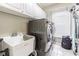 Well-equipped laundry room features modern washer and dryer, utility sink, and ample storage cabinets at 5317 Pagnotta Pl, Lutz, FL 33558