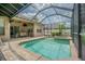 Screened-in pool with connected spa and brick pool deck with access to the home's covered outdoor dining area at 5317 Pagnotta Pl, Lutz, FL 33558