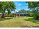 Wide shot of backyard featuring a screened-in pool area and lush green lawn, ideal for outdoor living at 535 Sandy Hook, Palm Harbor, FL 34683