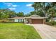 Charming single-story home featuring a manicured lawn, stone accents, and a two-car garage at 535 Sandy Hook, Palm Harbor, FL 34683
