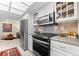 Modern kitchen with stainless steel appliances and white cabinets with glass display cases at 535 Sandy Hook, Palm Harbor, FL 34683