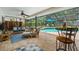 Relaxing screened patio featuring stylish furniture, a ceiling fan, and a view of the pool and backyard at 535 Sandy Hook, Palm Harbor, FL 34683