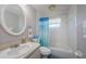 Bathroom with a decorative mirror, shower-tub combination and white tile at 6111 2Nd Ave, New Port Richey, FL 34653