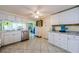 Well-lit kitchen featuring white cabinetry and a glimpse into the dining area at 6111 2Nd Ave, New Port Richey, FL 34653