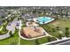 This aerial view shows a community pool, playground, parking, and clubhouse nestled in a neighborhood setting at 7225 Ronnie Gardens Ct, Tampa, FL 33619