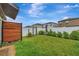 Landscaped backyard featuring a green lawn, privacy fence, and wood accent wall at 7225 Ronnie Gardens Ct, Tampa, FL 33619