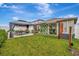 Backyard featuring a covered gazebo with seating, lush lawn, and vine covered wall at 7225 Ronnie Gardens Ct, Tampa, FL 33619