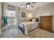 Bedroom featuring a large window, wooden dresser, and a ceiling fan fixture at 7225 Ronnie Gardens Ct, Tampa, FL 33619