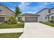 Charming single-Gathering home with a well-maintained lawn and a two-car garage on a sunny day at 7225 Ronnie Gardens Ct, Tampa, FL 33619
