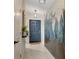 Stylish foyer featuring a decorative accent wall, modern lighting, and a welcoming blue door at 7225 Ronnie Gardens Ct, Tampa, FL 33619