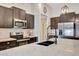 Modern kitchen featuring dark cabinetry, stainless steel appliances, and a spacious island with a marble countertop at 7225 Ronnie Gardens Ct, Tampa, FL 33619