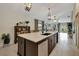 Open-concept kitchen featuring a large island with bar seating and modern pendant lighting at 7225 Ronnie Gardens Ct, Tampa, FL 33619