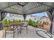 Covered patio seating area featuring an egg chair, dining table, and lush green privacy plants at 7225 Ronnie Gardens Ct, Tampa, FL 33619