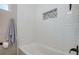 Clean white bathtub with white tiled walls and a decorative tile niche at 770 27Th S Ave, St Petersburg, FL 33705