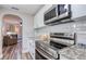 Modern kitchen featuring stainless steel appliances, granite countertops, and white subway tile backsplash at 770 27Th S Ave, St Petersburg, FL 33705