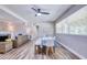 Living and dining space featuring wood floors, a ceiling fan, and ample natural light streaming through the windows at 770 27Th S Ave, St Petersburg, FL 33705