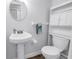Cozy bathroom with pedestal sink, toilet, and built-in storage above at 7801 11Th N St # 104, St Petersburg, FL 33702