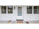 Charming entrance with white door flanked by windows, complemented by a colorful welcome mat at 7801 11Th N St # 104, St Petersburg, FL 33702