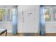 Front door is white with two side windows and curtains at 7801 11Th N St # 104, St Petersburg, FL 33702