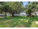 Sprawling green lawn, mature trees, and white buildings create a serene outdoor setting at 7801 11Th N St # 104, St Petersburg, FL 33702