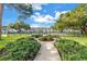 Beautiful community pool surrounded by lush landscaping, benches, and walking paths at 7801 11Th N St # 104, St Petersburg, FL 33702