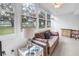 Cozy sunroom boasts large windows with lush views, comfortable sofa, and stylish decor at 7801 11Th N St # 104, St Petersburg, FL 33702