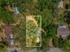 Aerial view of the lot surrounded by lush trees, with other homes close by at 7813 Cadillac Ave, Hudson, FL 34667