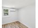 Bedroom with a window, white walls, an AC unit, and wood-look flooring at 7813 Cadillac Ave, Hudson, FL 34667